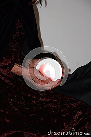 Hands cradling a glowing crystal ball Stock Photo